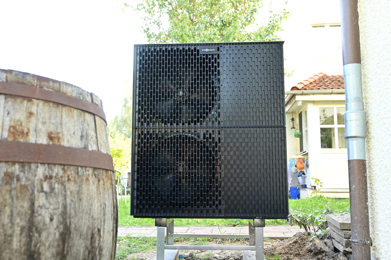 Schwarze Viessmann Vitocal Luft-Wasser-Wärmepumpe mit Doppellüfter im Garten – Referenzinstallation Haustechnik DEK